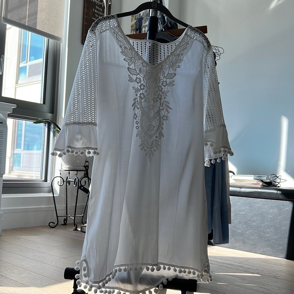 White, sheer bathing suit cover up. Size medium. Dangling poof balls.  Unused.